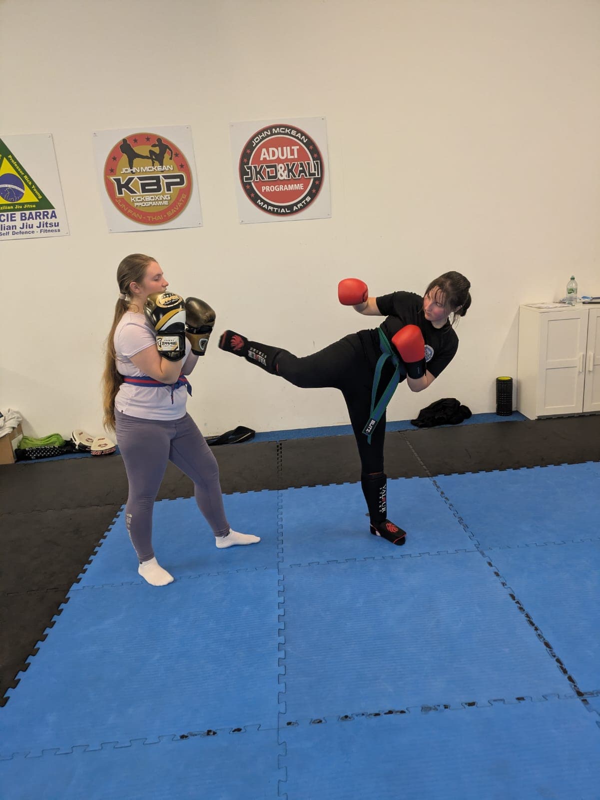 Teen martial arts students practising a controlled kickboxing drill
