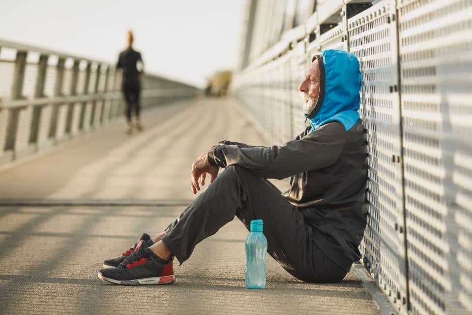 A runner pausing to reset beside a training route